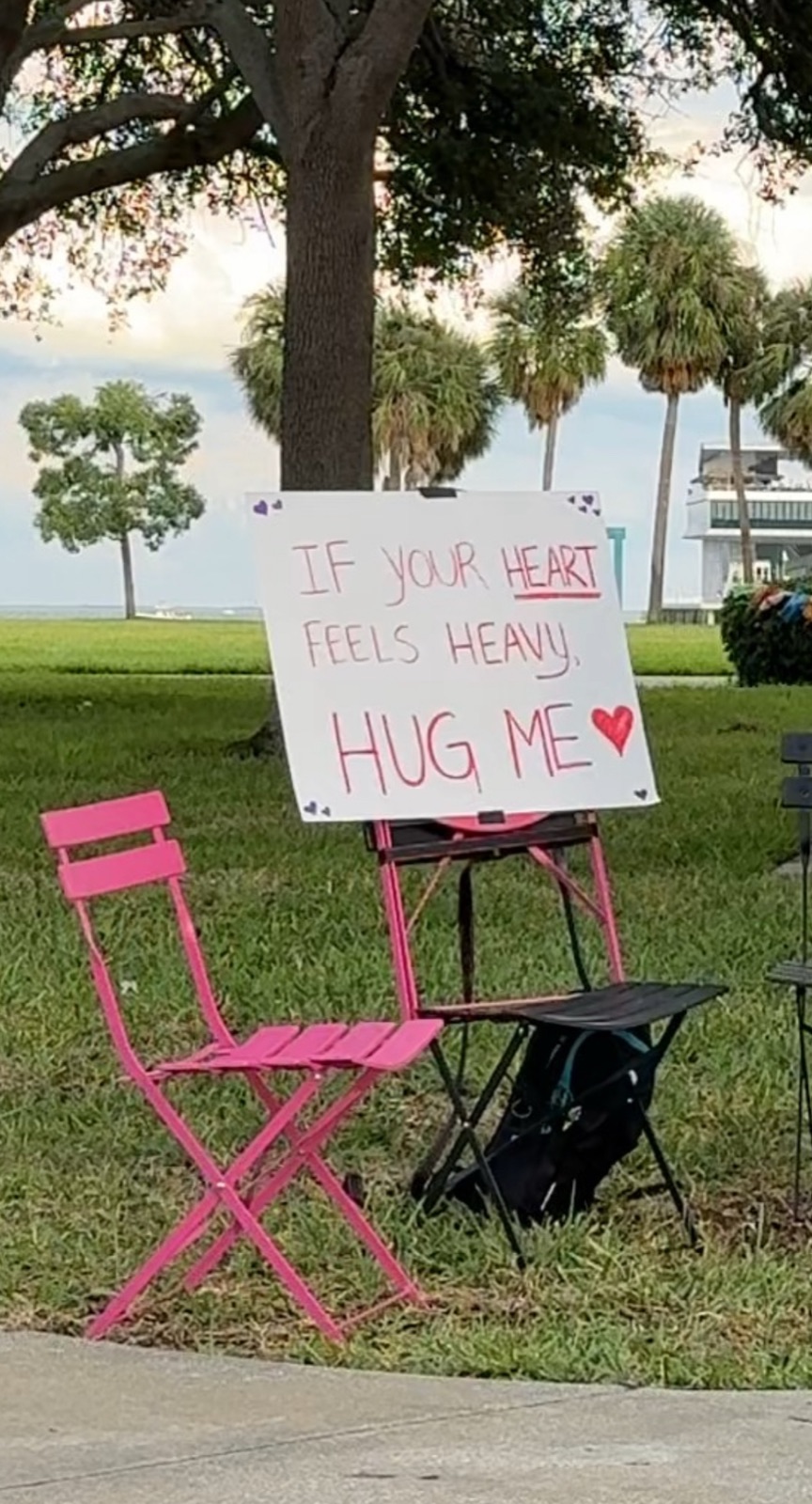 A pink chair with a sign that reads: If your heart feels heavy, hug me