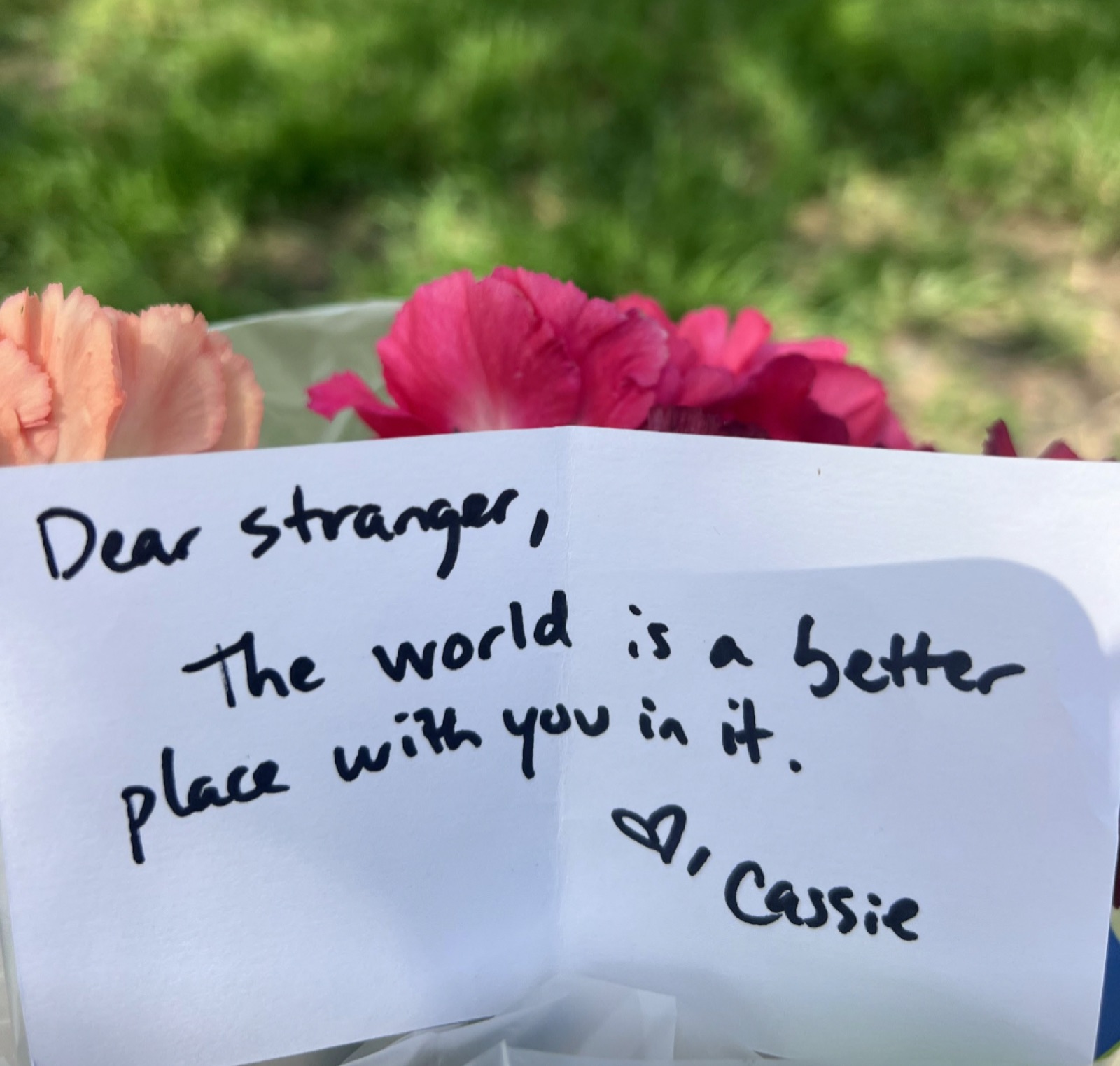 A handwritten note that reads: Dear stranger, the world is a better place with you in it. Cassie